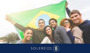 IDH Brésil - Photo montrant des jeunes devant le drapeau du Brésil pour l'article chez Solere-Avocats.Fr intitulé "IDH Brésil - L'indice de développement humain progresse au Brésil"